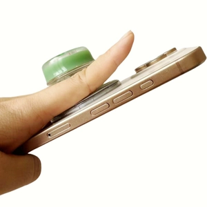 Green translucent donut pop socket showing secure finger grip on smartphone back