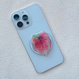 Macro detail of leaf-patterned phone grip on a white surface with realistic leaf texture