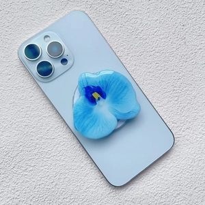 Detailed view of the blue orchid acrylic magnetic phone stand on a smartphone