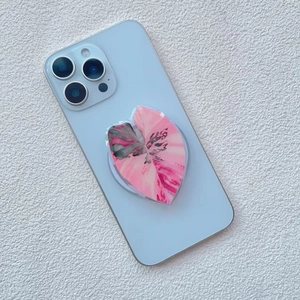 Detail of leaf pattern acrylic phone grip showing pink and green foliage texture