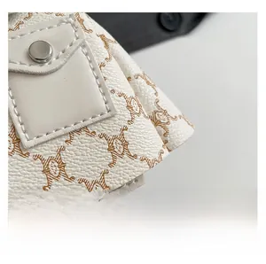 Detailed macro view of retro monogram pattern and silver snap button on beige crossbody bag