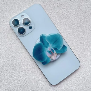 Detail of 3D blue orchid phone grip with clear acrylic finish on a blue smartphone