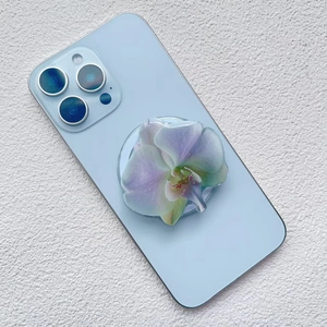 Detail of 3D acrylic orchid flower magnetic phone holder on a blue smartphone