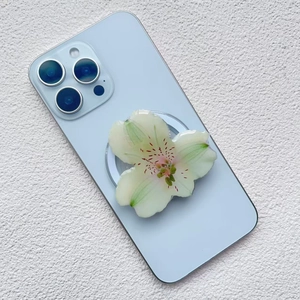 Detail view of the 3D orchid acrylic magnetic phone stand on a blue smartphone