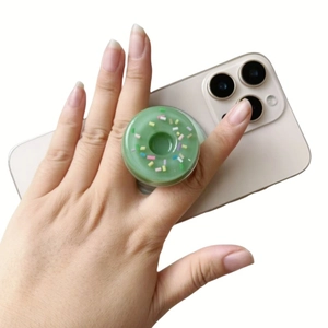 Creative green donut-shaped expandable phone socket grip on a smartphone back cover