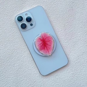Detail of leaf-shaped acrylic phone grip with pink vein pattern on a smartphone