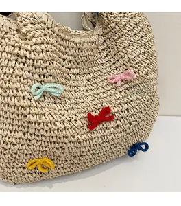 Close-up of beige straw woven tote bag featuring colorful handmade crochet bows and fine texture