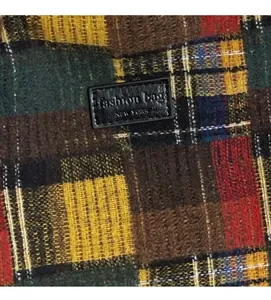 Close-up of retro plaid fabric and black leather label on a large tote bag