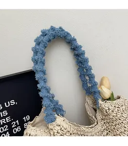 Detailed view of handmade straw tote bag with bright blue frayed texture shoulder straps