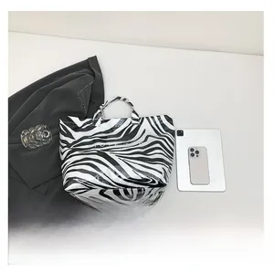 Détail du sac cabas zébré avec inscription TOTE BAG montrant la texture et les anses