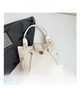 Détail du sac cabas blanc cassé avec texture litchi, fermetures éclair et boucle en métal rétro
