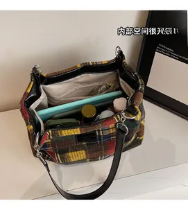 Interior view showing the large capacity with tablet and pockets in a plaid tote bag