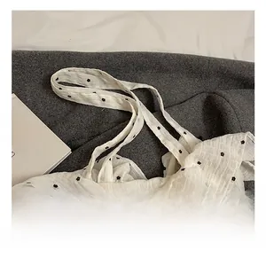 Detail shot of the white floral tote bag featuring crinkled texture and dual fabric handles
