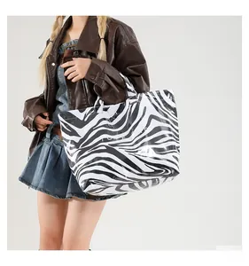 Détail du sac cabas à imprimé zèbre avec finition brillante et lettrage TOTE BAG