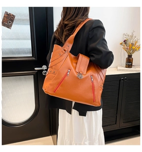 Grand sac cabas orange en similicuir avec fermetures éclair porté par un mannequin