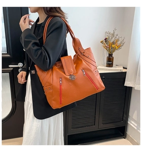 Détail du grand sac cabas orange en similicuir avec coutures et rivets latéraux