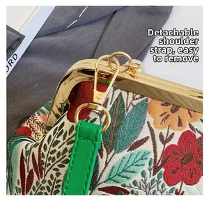 Detail of floral embroidery fabric and detachable green leather strap with gold hardware