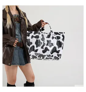 Gros plan d'un grand sac cabas à motif léopard porté par un mannequin en veste de cuir