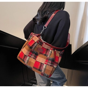 Detail of red plaid tote bag featuring thick tweed fabric and leather shoulder strap
