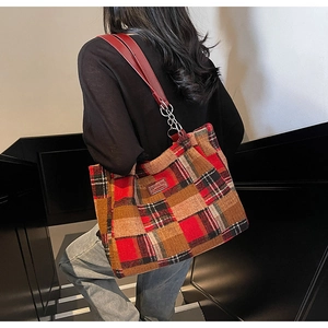 Close-up of vintage red plaid tote bag with faux leather and metal chain straps