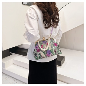 Floral embroidery handbag with pearl handle and purple strap on a model back view