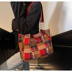 Detail of red tweed plaid tote bag with leather straps and silver metal hardware