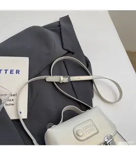 Détail du sac à bandoulière en cuir crème avec sangle réglable et boucle en métal