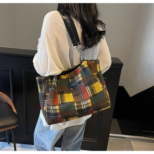 Detail of multi-color plaid tote bag showing woven texture and metal chain strap