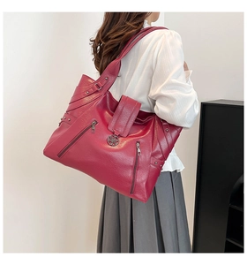 Détail du sac fourre-tout bordeaux en similicuir avec zip latéral et boucle métallique