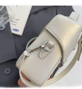Détail du mini sac carré blanc perlé avec des crochets métalliques argentés haut de gamme