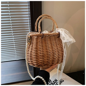 Detailed straw woven bag featuring a wooden handle, lace bow, and elegant pearl strap