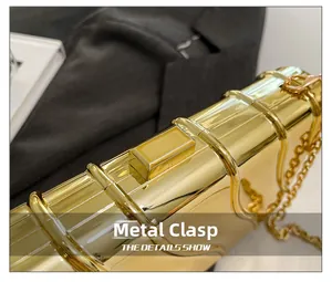 Dettaglio della pochette da sera in metallo dorato lucido con chiusura a scatto superiore