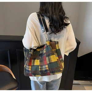 Detail view of colorful plaid tote bag with thick tweed texture and metal chain strap