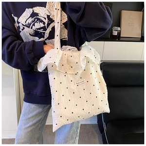 Detailed shot of white tote bag featuring star pattern and ruffled edge design