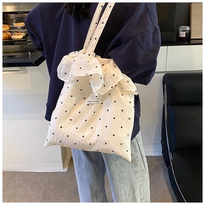 Detail of white floral chiffon tote bag featuring Magic Pocket label and ruffle edges