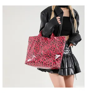 Gros plan sur un sac cabas léopard rouge avec finition brillante et lettrage blanc