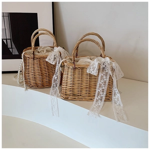 Detailed view of woven straw basket bag featuring white lace trim and pearl handle