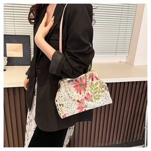 Detail of floral vintage clasp bag with pearl handle and pink leather strap
