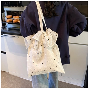 Detail of white ruffle tote bag with floral pattern and Magic pocket woven label