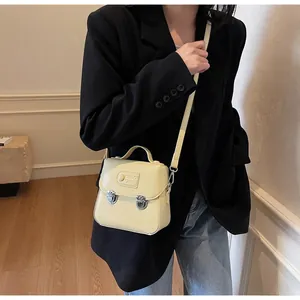 Vue détaillée du mini sac vintage jaune pâle en cuir mat avec fermoir métallique