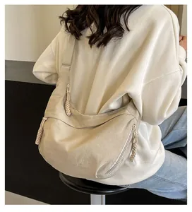 Detailed back view of a beige crescent crossbody bag showing its nylon texture and size