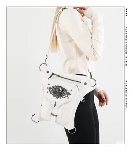 Macro shot of white gothic steampunk leg bag with metal skull relief and studs