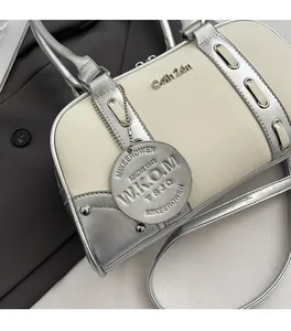 Detail of Boston handbag featuring silver logo tag and grain leather texture