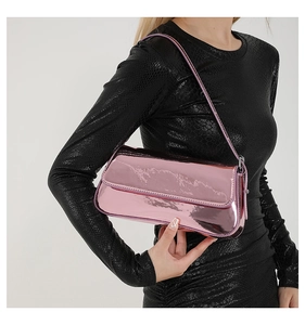 Detail of pink metallic patent leather baguette bag with shiny mirror finish on model