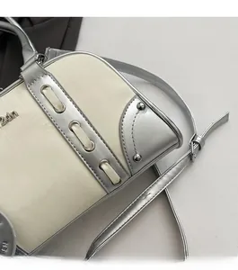 Detail of color-block Boston bag with silver studs and precision stitching craftsmanship