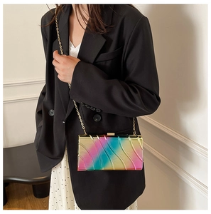 Detail of colorful acrylic box clutch with wave texture and golden chain strap
