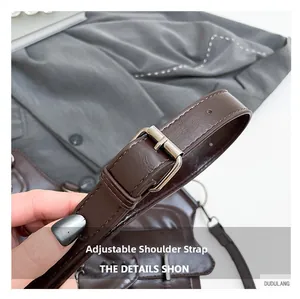 Close-up of adjustable dark brown leather shoulder strap with silver metal buckle detail
