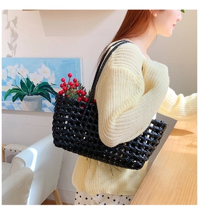 Detailed view of black hollow woven tote bag with glossy straps and spacious mesh interior