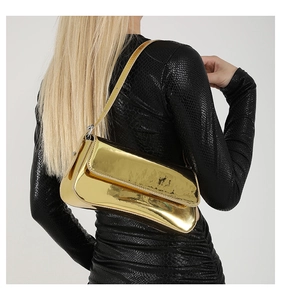 Glossy gold mirror finish shoulder bag paired with an elegant black snake-print dress