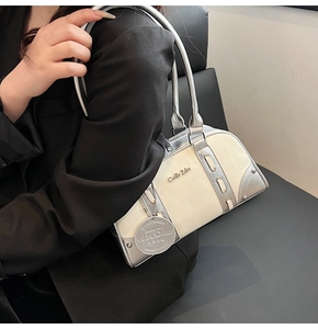 Detail of Boston bag showing textured off-white faux leather and silver metal logo hardware